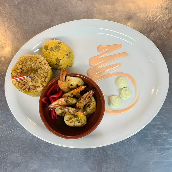 Grilled shrimp in a brown bowl, two rice mounds, and sauces on a white plate.